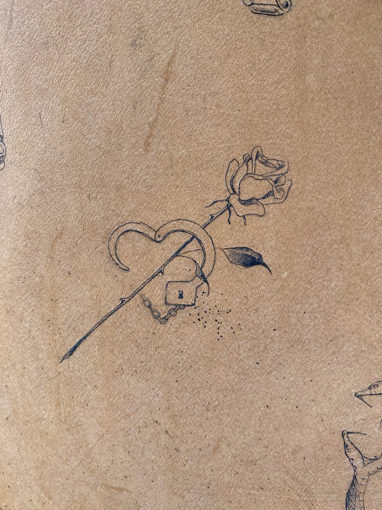 Tattooed leather image of rose and handcuff by Kane Navasard